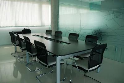 Sala de conferencias elegante con sillas negras elegantes y un diseño moderno de pared de vidrio.